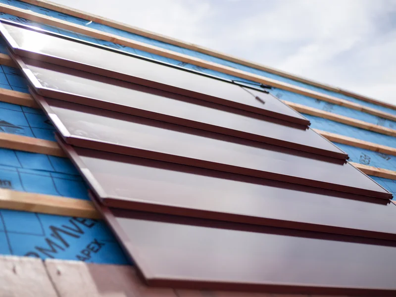 Close product detail of red SolarTyle modules installed within the roof line