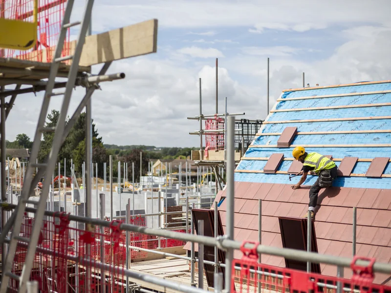 SolarTyle installer working on a red roof within the Moor Hall Road development