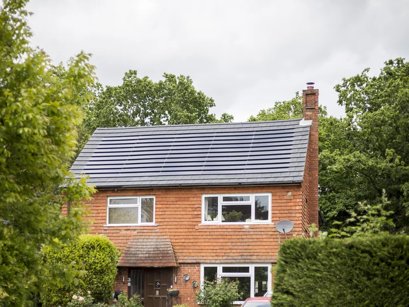 Completed grey SolarTyle roof integrated into an existing brick home