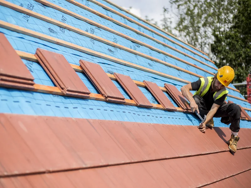 SolarTyle installer fitting red integrated roof tiles at Moor Hall Road