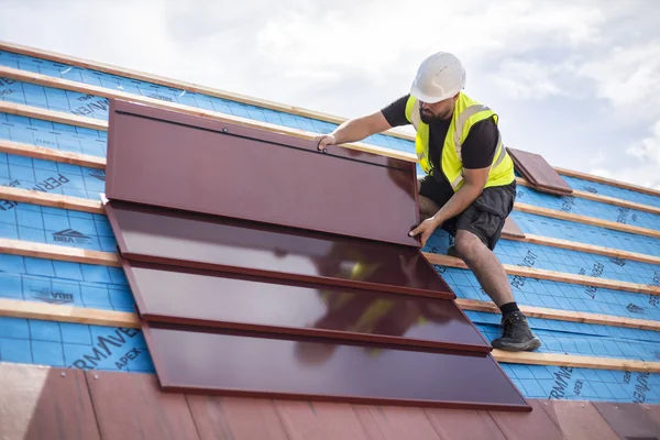 An installer fitting genuine red SolarTyle modules at Moor Hall