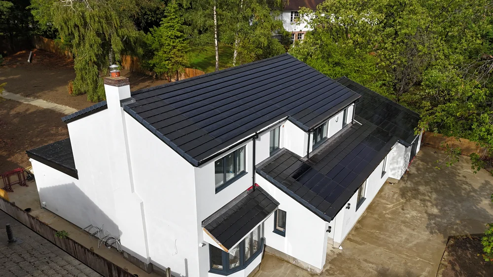 A second aerial view showing the integrated solar roof in the setting of the property