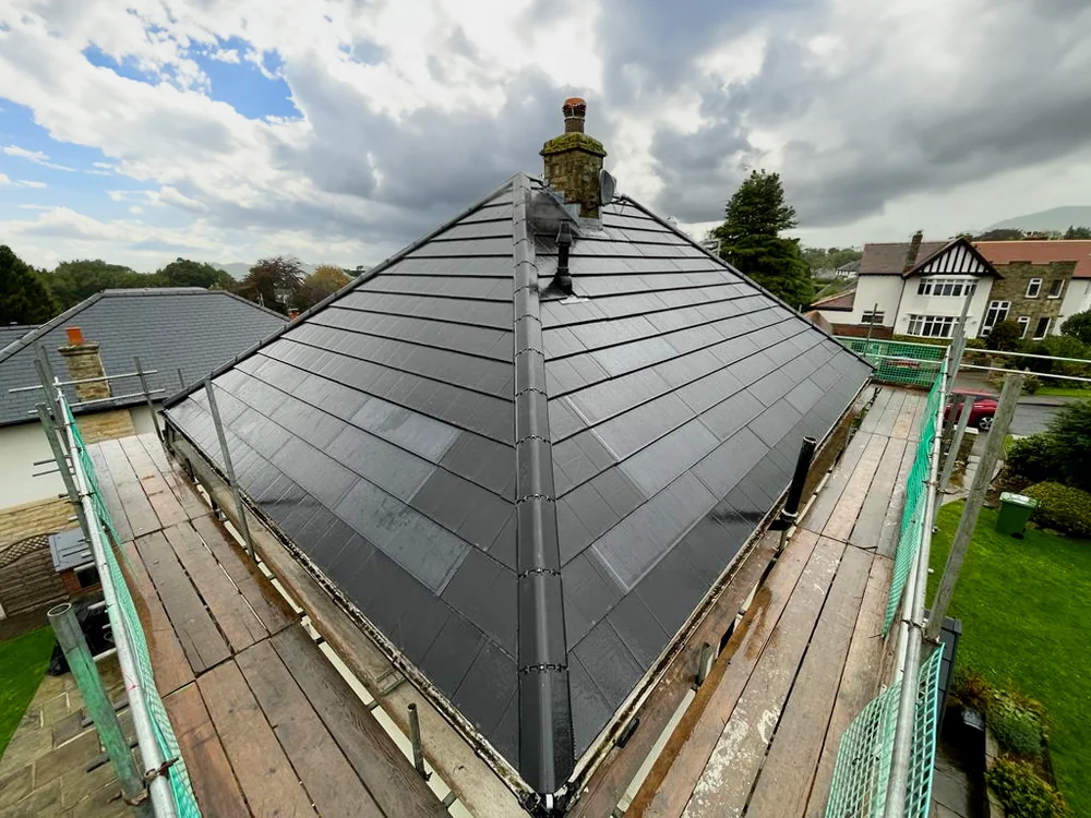 SolarTyle courses beside the chimney, with scaffolding still in place