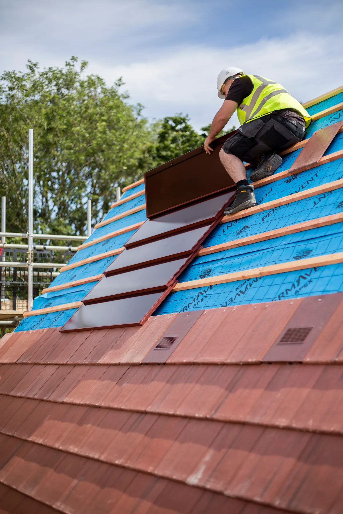 Installer positioning an integrated SolarTyle unit on a prepared roof