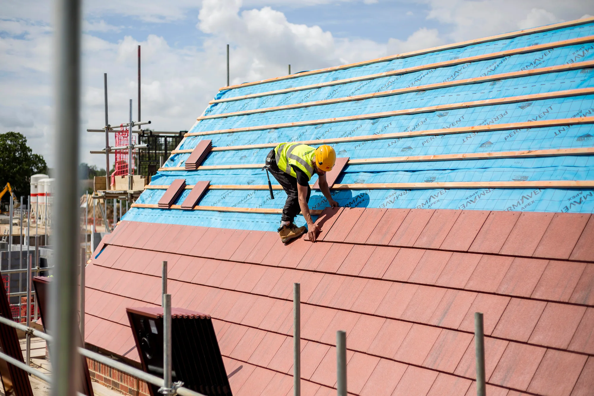 SolarTyle installer working across the prepared roof and timber batten layout