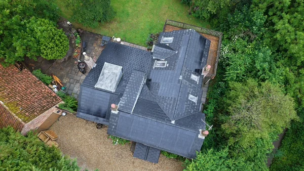 The cottage and extension roofs within the surrounding grounds