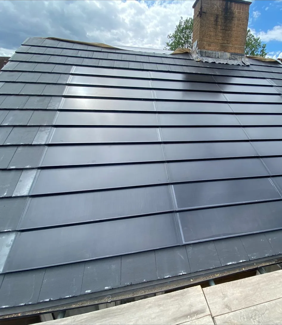 Integrated anthracite SolarTyle courses beside the chimney at Bowerman Avenue